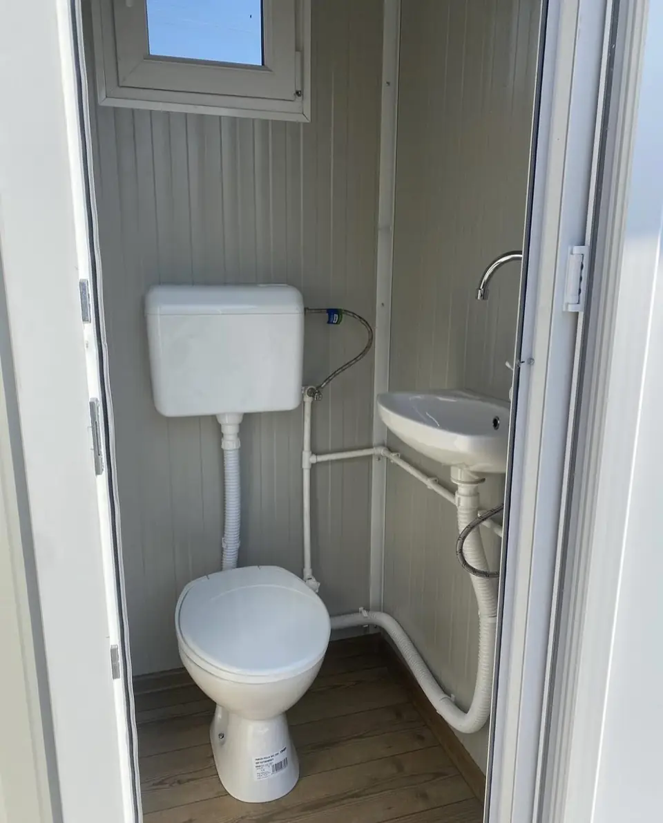 Flush toilet and corner sink inside a deluxe portable restroom