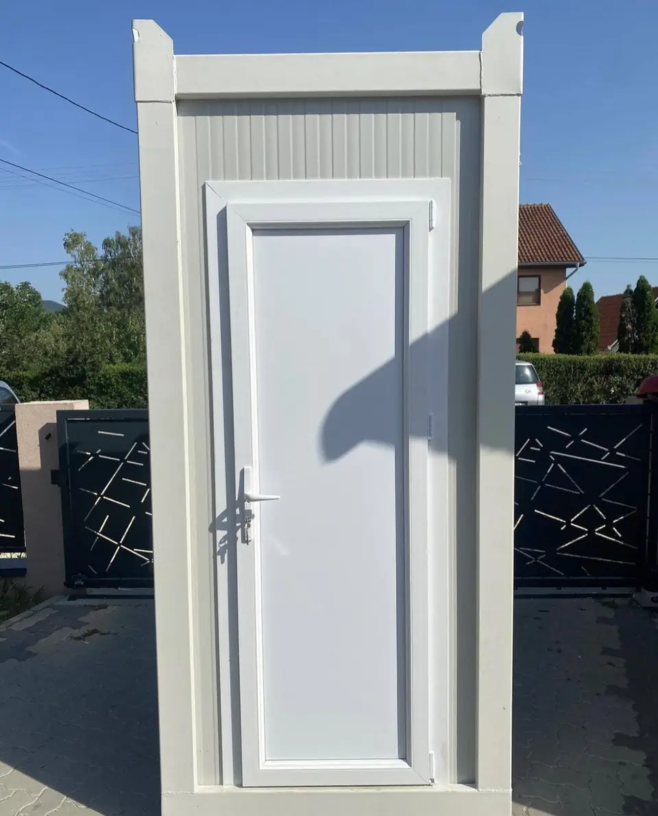White deluxe portable restroom cabin standing in a driveway