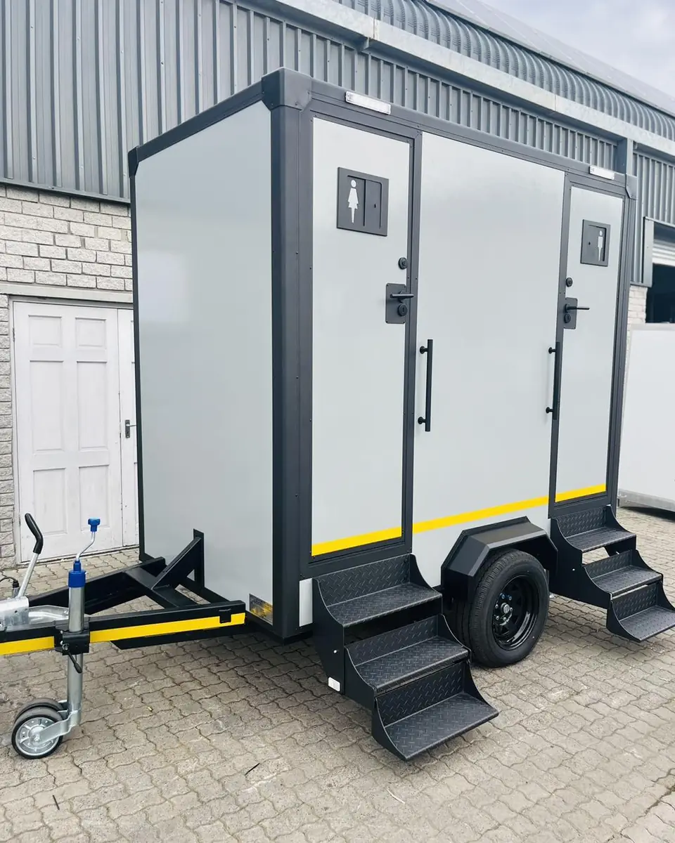Two-stall restroom trailer with separate doors and steps